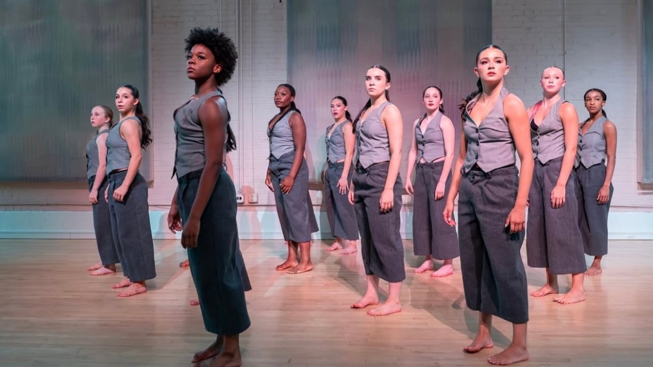 Coalesced — ensemble of dancers in grey vests standing in formation