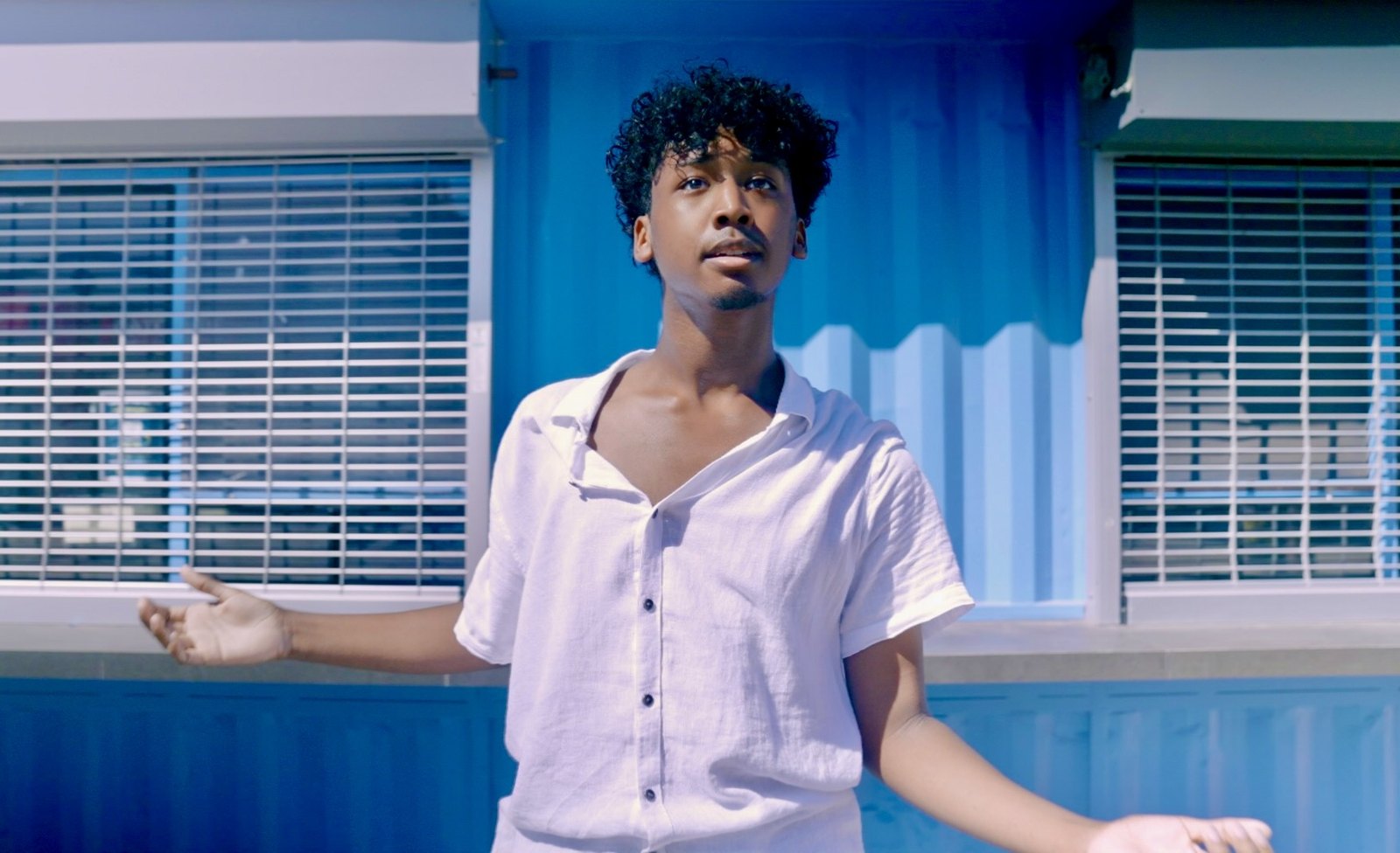 Just For Me — performer in white against a blue building
